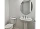 Clean powder room with pedestal sink and round mirror at 9433 Barnacle Ln, Parrish, FL 34219