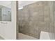 Walk-in shower with gray tile and built-in seat at 9433 Barnacle Ln, Parrish, FL 34219