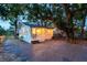 Cottage exterior at night with string lights and stone patio at 3170 6Th S Ave, St Petersburg, FL 33712