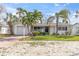 Charming home featuring a brick driveway, a front lawn, and mature palm trees at 422 86Th Ave, St Pete Beach, FL 33706