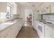 Galley kitchen featuring white cabinetry, modern appliances, and a cozy dining nook in a sunlit space at 422 86Th Ave, St Pete Beach, FL 33706