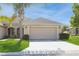 Tan one-story house with attached garage, palm tree, and well-manicured lawn at 13640 Eastfork Ln, Hudson, FL 34669