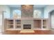 Stone fireplace with built-in shelving and hardwood floors at 16623 Ashton Green Dr, Lutz, FL 33558