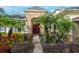 Elegant front entrance with stonework, lush landscaping, and a red door at 16623 Ashton Green Dr, Lutz, FL 33558