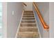 Carpeted staircase with wooden handrail leading to the upper level at 16623 Ashton Green Dr, Lutz, FL 33558