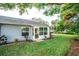 Home's backyard with lush lawn, mature trees, and a screened porch at 905 Oxford Park Dr, Sun City Center, FL 33573