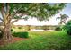 Serene backyard with lake view and lush landscaping at 905 Oxford Park Dr, Sun City Center, FL 33573