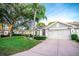 Gray house with two-car garage, palm trees, and well-maintained lawn at 905 Oxford Park Dr # A, Sun City Center, FL 33573