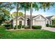 Two-story house with gray siding, palm trees, and manicured landscaping at 905 Oxford Park Dr, Sun City Center, FL 33573