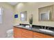 Double vanity bathroom with granite countertop and large mirrors at 1580 Mac Chesney Dr, Tarpon Springs, FL 34689