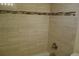 Shower with tan tiling and decorative mosaic tile accent stripe and brushed metal fixtures at 4108 Pinelake Ln # 102, Tampa, FL 33618