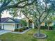 Single-story home with attached garage, landscaping, and large shade tree at 7123 Colonial Lake Dr, Riverview, FL 33578