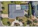 Aerial view of a home showcasing its roof, screened pool, landscaping, and circular driveway at 910 Oakwood Dr, Largo, FL 33770