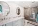 Modern bathroom with double vanity, glass shower, and gray tile at 910 Oakwood Dr, Largo, FL 33770