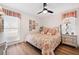 Bright bedroom with floral bedding, wood floors, and ceiling fan at 910 Oakwood Dr, Largo, FL 33770