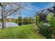 Pond-view backyard with lush grass and a screened patio at 7820 Harbor Bridge, New Port Richey, FL 34654