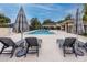 Community pool area with lounge chairs and umbrellas at 7820 Harbor Bridge, New Port Richey, FL 34654