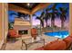 Relaxing patio with fireplace, comfortable seating, and pool access at 101 12Th E St, Tierra Verde, FL 33715