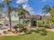 Lush landscaping accents this beautiful home with a large driveway, covered front porch, and archway entry at 208 Driftwood Ln, Largo, FL 33770