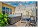 Relax in this screened-in hot tub with lounge chairs and lush plants at 1647 Emerald Dunes Dr, Sun City Center, FL 33573