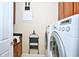 Convenient laundry room with washer, dryer, and built-in shelving at 1647 Emerald Dunes Dr, Sun City Center, FL 33573