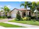 Single-story home with a tan exterior, white garage door, and landscaped front yard at 200 Soliera St, Nokomis, FL 34275