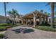 Attractive community entrance with covered walkway and lush landscaping at 2226 Sifield Greens Way # 26, Sun City Center, FL 33573