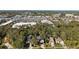 An aerial view of homes near retail and roadways, set against a backdrop of lush greenery and distant cityscape at 2457 Hickman Cir, Clearwater, FL 33761