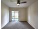 Neutral bedroom featuring carpeted floors, a ceiling fan, and sliding glass doors to the backyard at 3915 W San Pedro St, Tampa, FL 33629