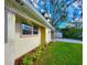 Home exterior featuring a well-maintained lawn, colorful shrubbery, and attached carport at 3915 W San Pedro St, Tampa, FL 33629