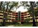 Condo building with lush landscaping and a central entrance at 3076 Eastland Blvd # 106, Clearwater, FL 33761