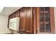 Close-up of wood kitchen cabinets with glass-front doors at 3076 Eastland Blvd # 106, Clearwater, FL 33761