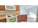 Bright kitchen with white appliances and wood cabinets at 3076 Eastland Blvd # 106, Clearwater, FL 33761