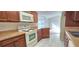 Well-equipped kitchen featuring wood cabinets and white appliances at 3076 Eastland Blvd # 106, Clearwater, FL 33761