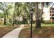 Landscaped pathway with mature trees and park benches at 3076 Eastland Blvd # 106, Clearwater, FL 33761