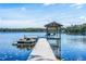 Expansive lakefront dock with covered seating area and jet ski lift at 7205 N Mobley Rd, Odessa, FL 33556