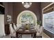 Elegant dining room featuring a large arched window and a rich wood table at 10097 Holly Berry Dr, Weeki Wachee, FL 34613