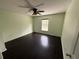 Bright bedroom with dark hardwood floors and ceiling fan at 3336 Bellericay Ln, Land O Lakes, FL 34638