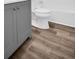 Gray vanity, toilet, and wood-look flooring at 3499 Cedar Ln, Palm Harbor, FL 34684