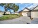 Exterior view of the house with a driveway and garage at 3499 Cedar Ln, Palm Harbor, FL 34684