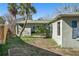 Home's backyard with a large palm tree and partial view of a fence at 7060 Boca Ciega Dr, St Pete Beach, FL 33706