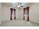 Spacious bedroom with carpeting, ceiling fan, and burgundy curtains at 790 7Th Ne Ave, Largo, FL 33770