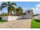 Home's driveway and front yard with palm trees at 790 7Th Ne Ave, Largo, FL 33770