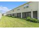 A manicured lawn is adjacent to the screened-in patios of these townhomes at 19157 Elsimont Isle, Lutz, FL 33558