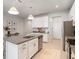 A kitchen boasts white cabinets, stainless steel appliances, and stone countertops at 19157 Elsimont Isle, Lutz, FL 33558