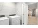 The laundry room features a white washer, dryer, and shelving for ample storage at 19157 Elsimont Isle, Lutz, FL 33558