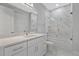 Bathroom with white vanity, marble shower, and bathtub at 7214 N Blossom Ave, Tampa, FL 33614