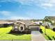 One-story home with a two-car garage, landscaping, and a palm tree in the front yard at 11101 58Th Street E Cir, Parrish, FL 34219