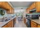 Open kitchen features granite counters, wood cabinets, and views to dining area at 19807 Gulf Blvd # 128, Indian Shores, FL 33785