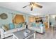 Living room with light walls, wood-look floors, and view of kitchen at 19807 Gulf Blvd # 128, Indian Shores, FL 33785